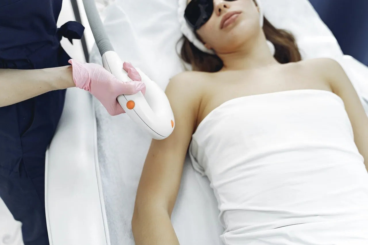 laser hair removal of the hands close-up, the girl lies in the cosmetologist's office in protective glasses from the laser irradiation smiles, the doctor removes the hair with a laser | Femme Moderne Center for Aesthetics in Draper, Utah