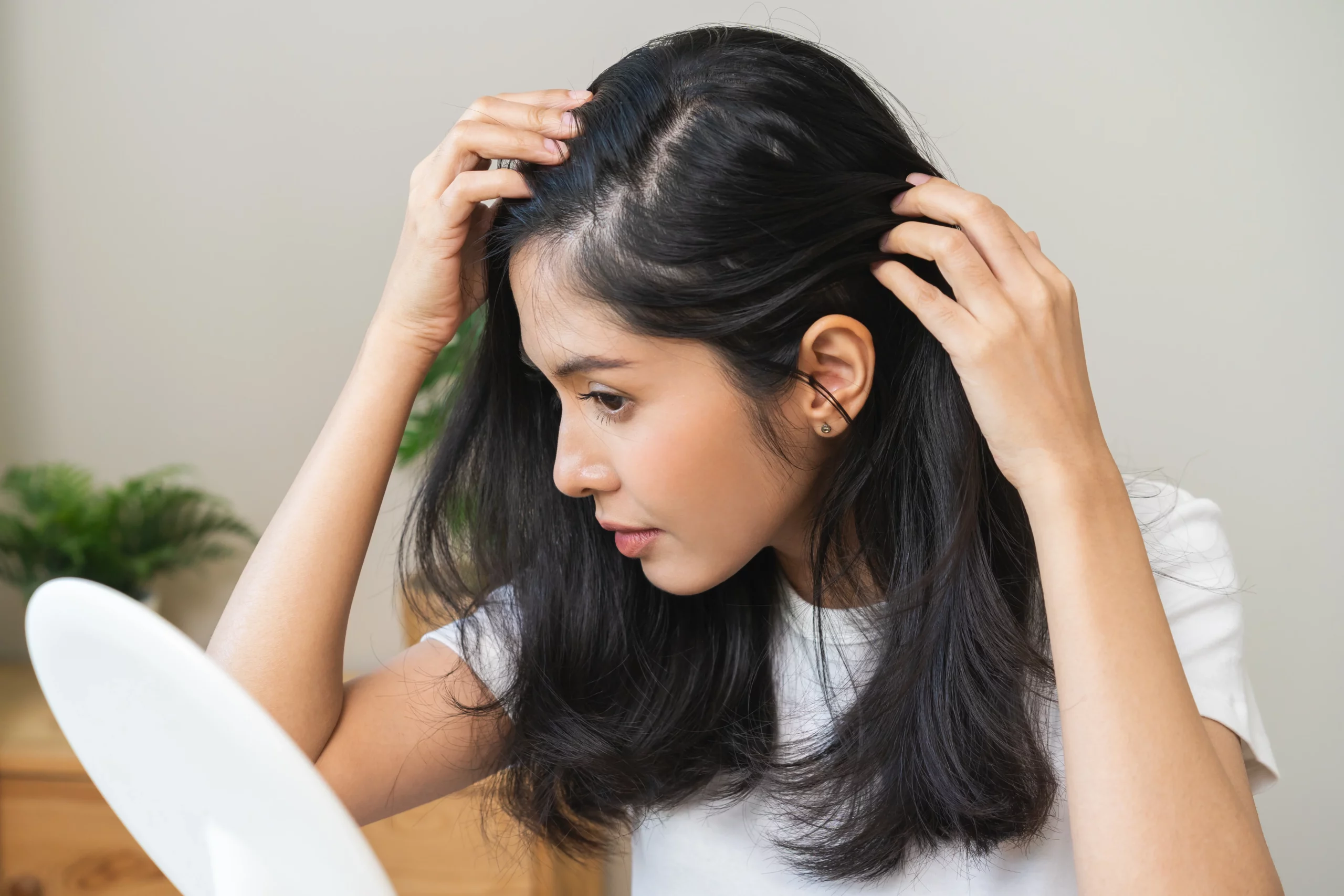 A woman see their hair in mirror Thinning Hair Treatment in Draper, UT